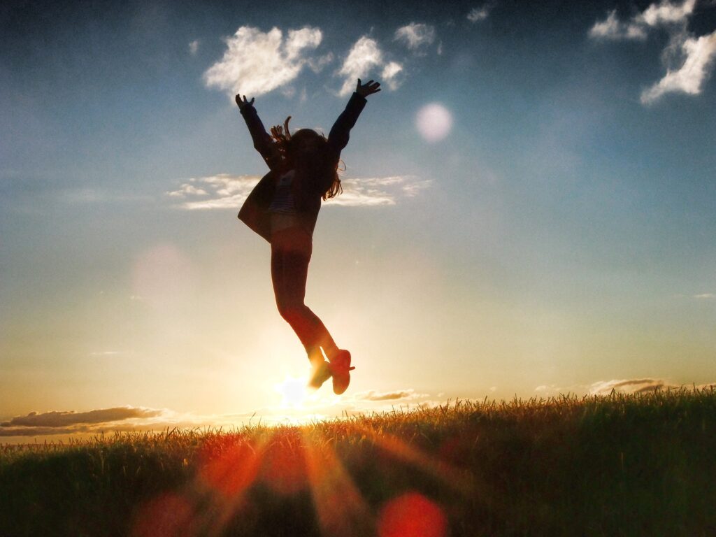 Silhouette of a person jumping into the air at sunset or sunrise